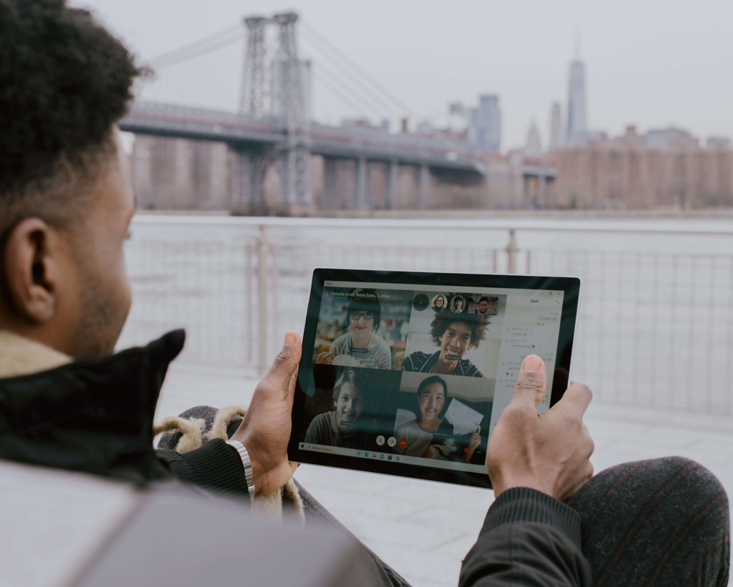 A man in a video call with 4 other people