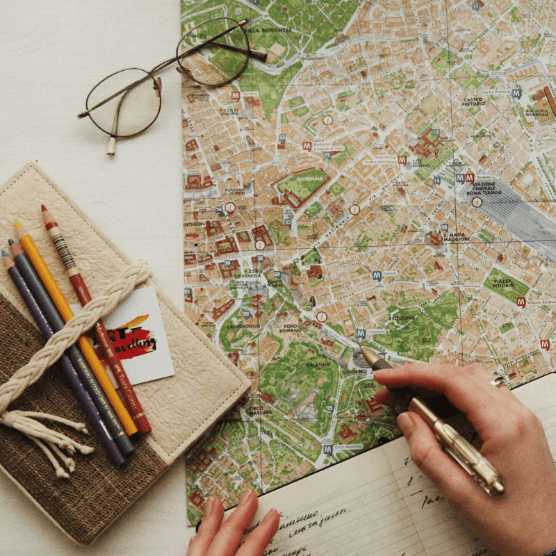 a map laid on a table with pencils to the side of it