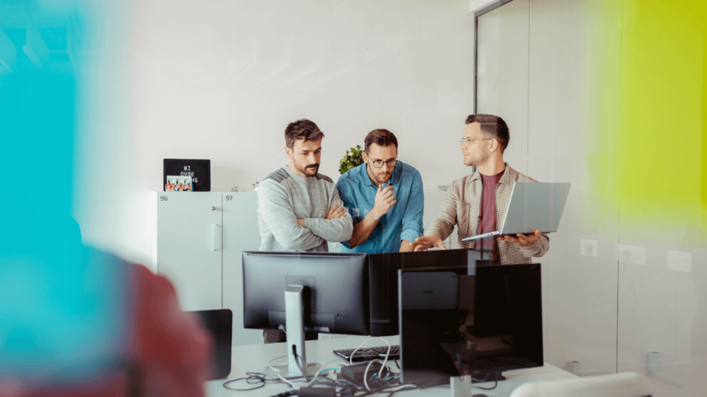 Three men looking as a monitor