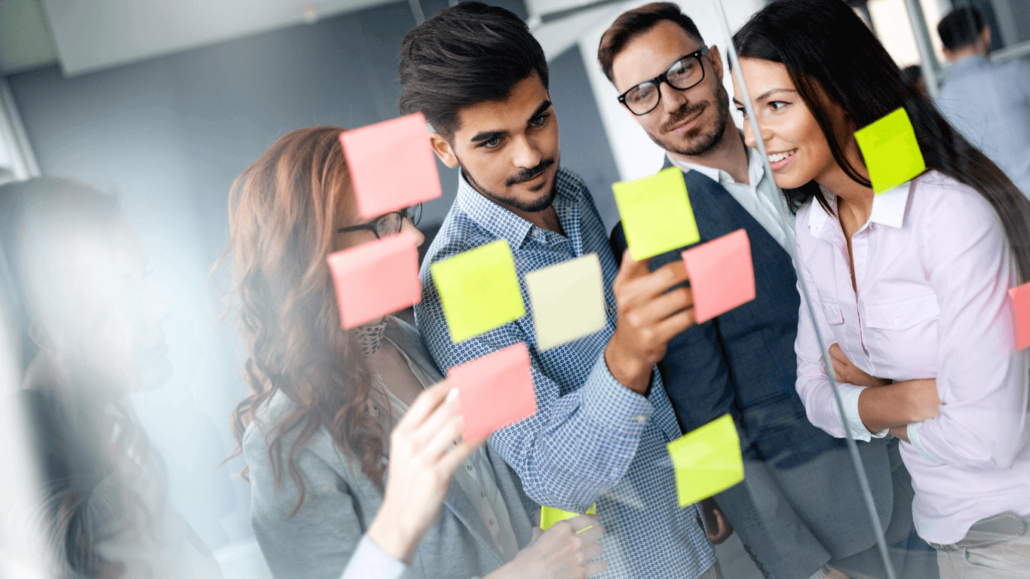 group of diverse individuals brainstorming using sticky notes