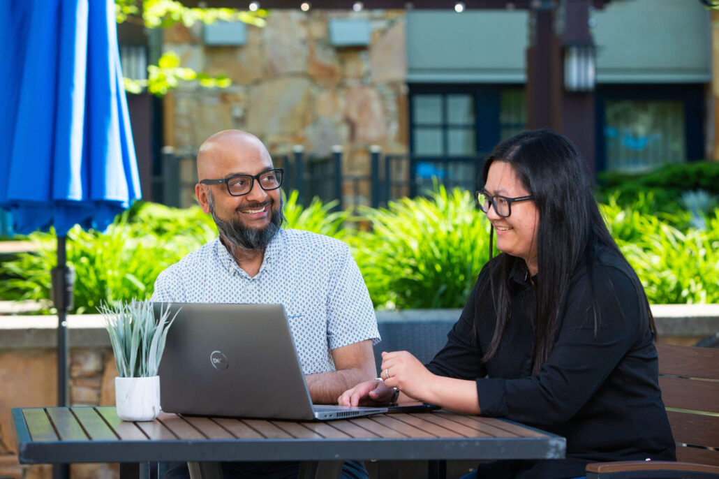 man and woman collaborating beside a laptop