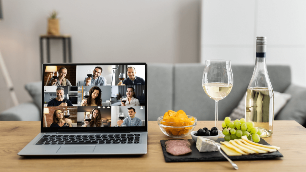 a laptop showing a video call of people holding wine glasses up.