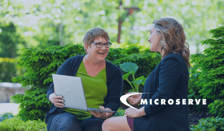 Two women smiling while discussing