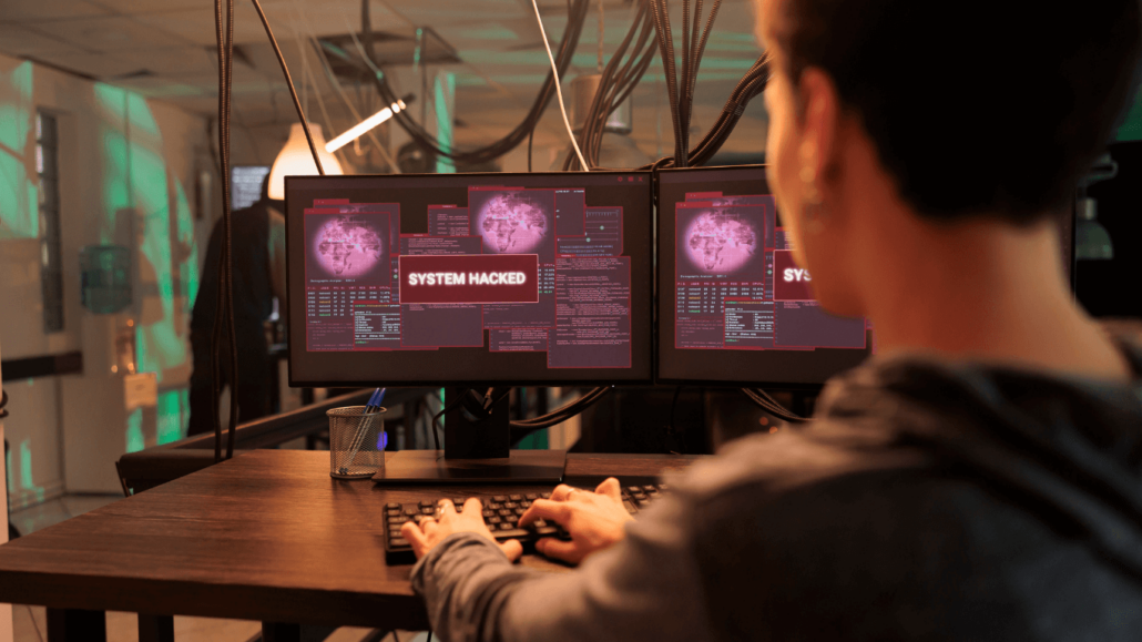 Man looking at hacked computer monitors